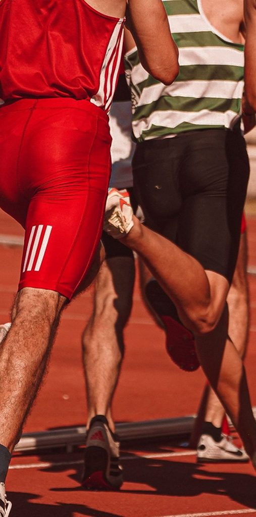 Dynamic view of male athletes running in a competitive track race outdoors.