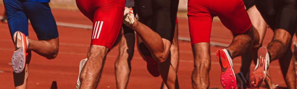 Dynamic view of male athletes running in a competitive track race outdoors.